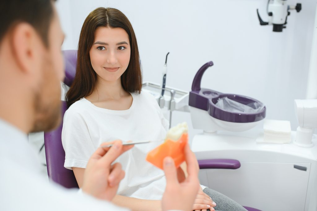 Dentist explaining the difference between a dental crown and a tooth-colored filling to a patient